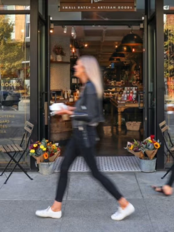 Woman walking past retail store.