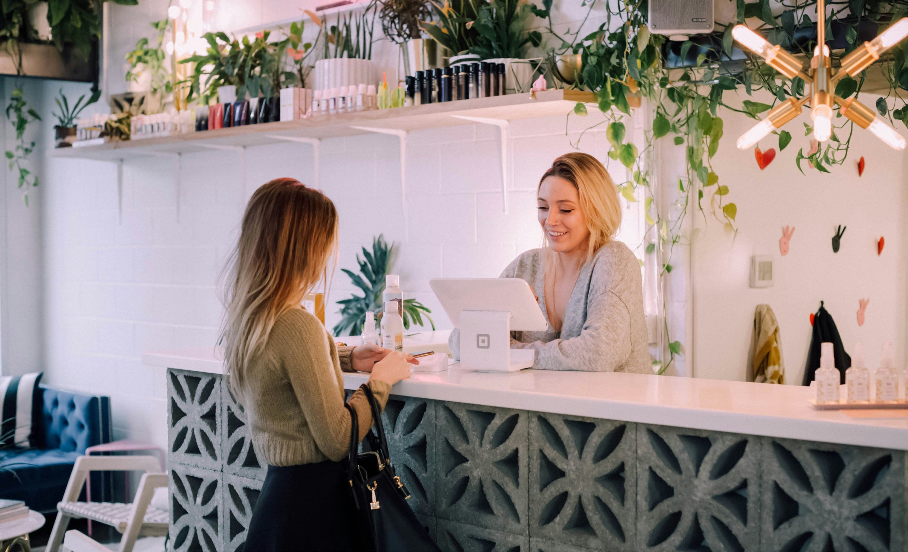 Employee using Square POS on retail store counter.