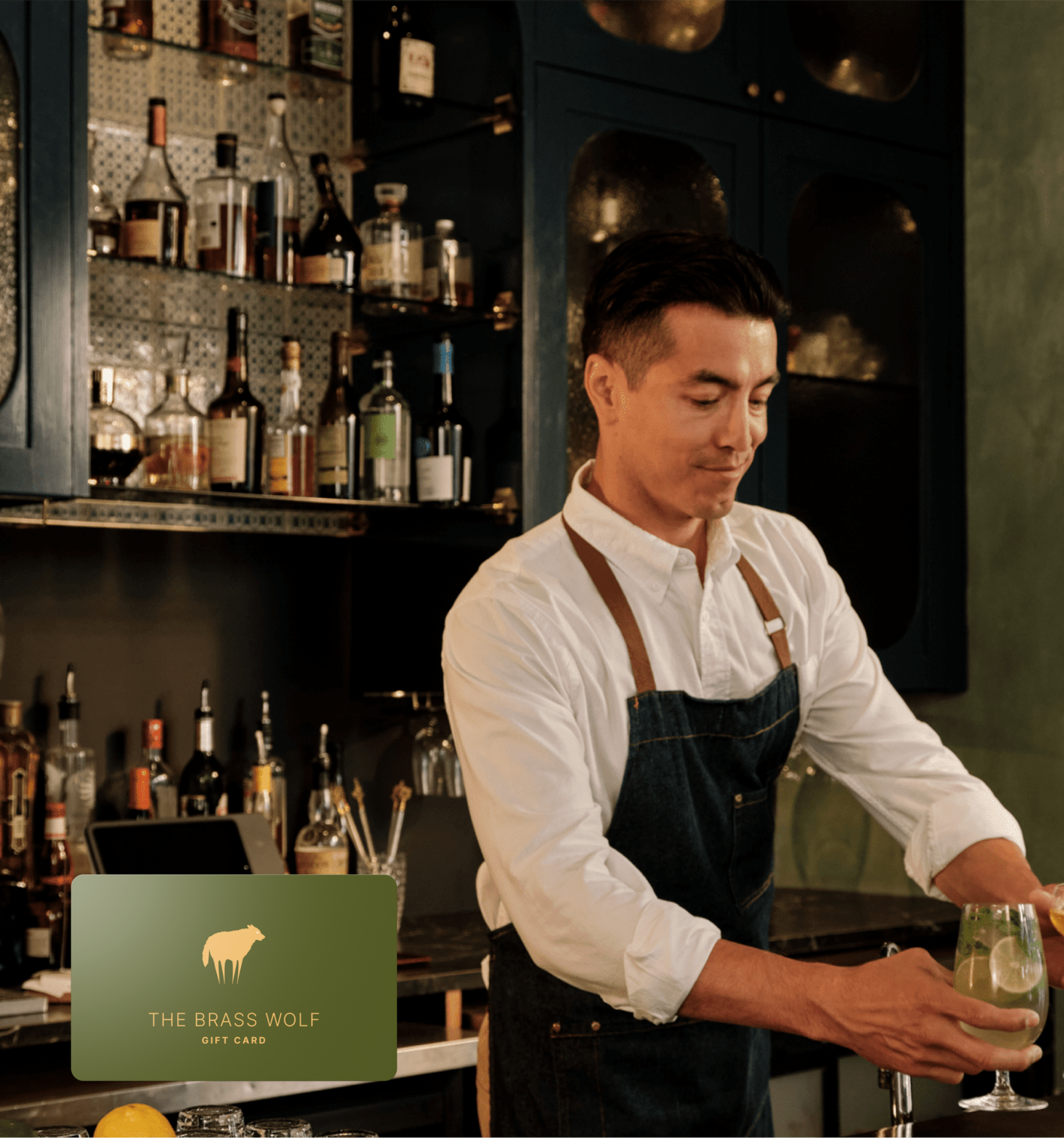 Bartender behind upscale bar and branded gift card in the corder.